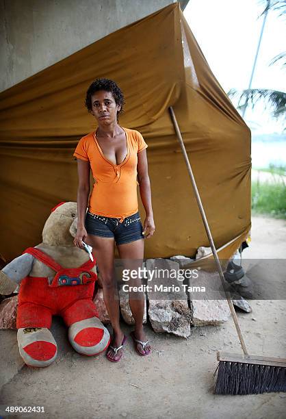Viviane Sabino de Souza poses outside her makeshift dwelling beneath a stretch of the Transcarioca BRT highway being constructed on May 9, 2014 in...
