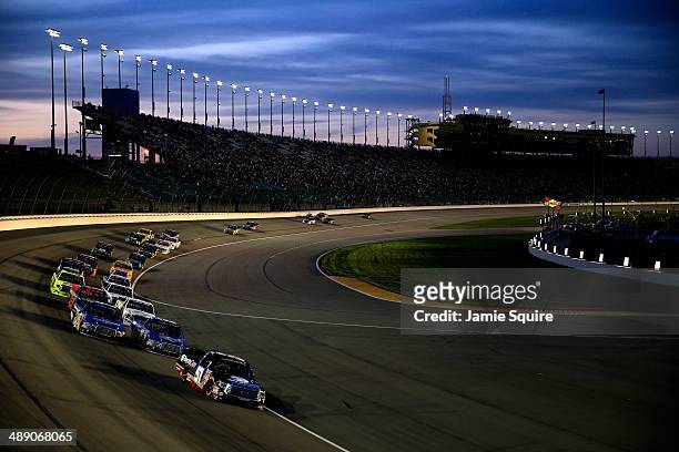 Kyle Busch, driver of the ToyotaCare Toyota, leads the field in a restart during the NASCAR Camping World Truck Series SFP 250 at Kansas Speedway on...