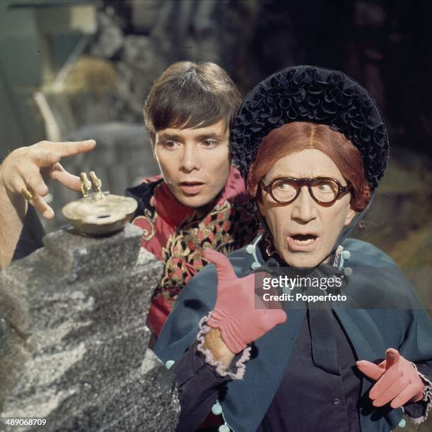 English singer and actor Cliff Richard pictured with the comedian Arthur Askey in a scene from the television adaptation of the pantomime 'Aladdin'...
