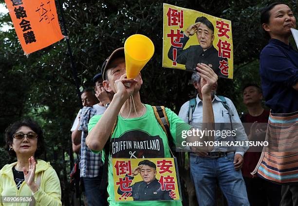 People hold placards to protest against Japan's Prime Minister Shinzo Abe's controversial security bills near the National Diet in Tokyo on September...