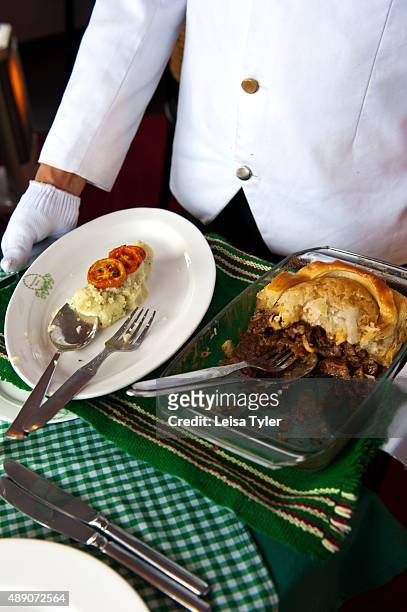 Waiter serving steak and kidney pie with mashed potatoes and grilled tomatoes at the colonial era Windamere Hotel in Darjeeling, India.