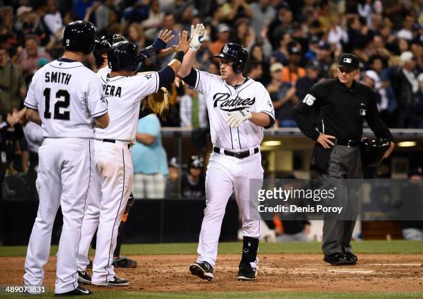 Jedd Gyorko of the San Diego Padres, center, is congratulated by his teammates after hitting a grand slam during the sixth inning of a baseball game...