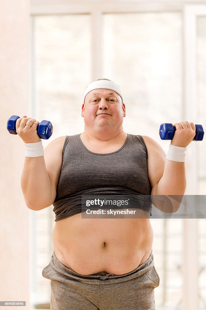 Fat Man Weightlifting And Looking At Camera High-Res Stock Photo