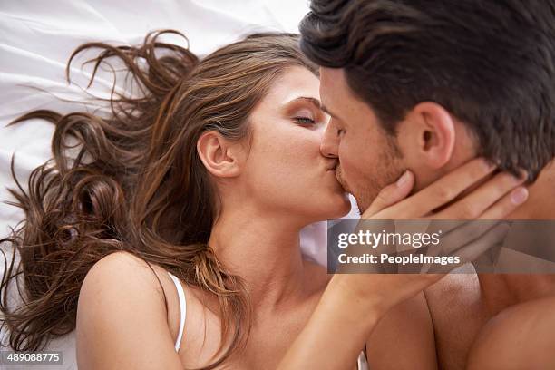 living the fairytale fantasy - man and woman kissing in bed stock pictures, royalty-free photos & images