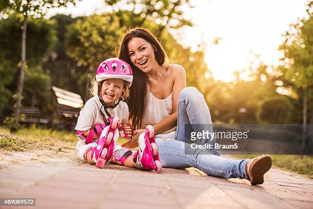 cheerful girl with rollerblades and her young mother in nature. - protective sportswear stock pictures, royalty-free photos & images