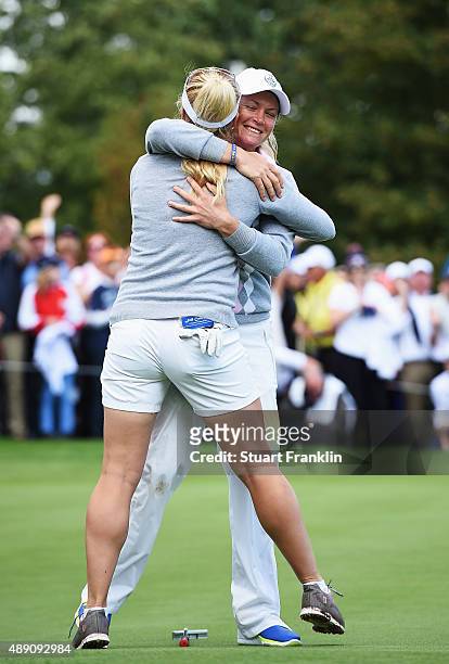 Suzann Pettersen of team Europe celebrates with Charley Hull after winning their match during the morning foursomes matches at The Solheim Cup at St...