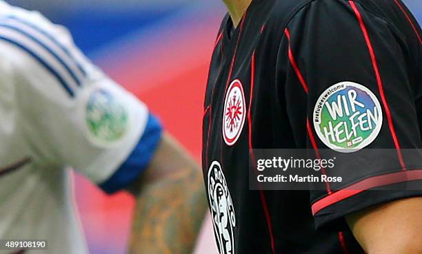 Players of Frankfurt wear the 'Wir Helfen' badge on the shirt during the Bundesliga match between Hamburger SV and Eintracht Frankfurt at...