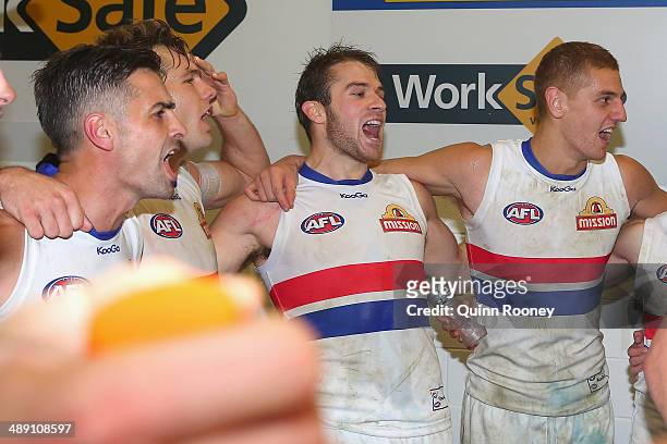 Daniel Giansiracusa, Shaun Higgins, Stewart Crameri and Liam Jones of the Bulldogs sing the song in the rooms after winning the round eight AFL match...