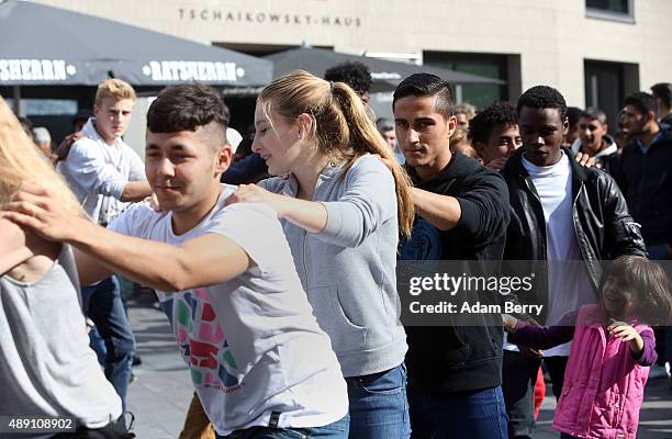 Refugees and a locals dance with one another at a welcome festival for migrants on September 19, 2015 in the Karolinenviertel neighborhood of...