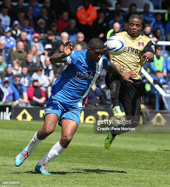 Mark Little of Peterborough United attempts to clear the ball under pressure from Kevin Lisbie of Leyton Orient during the Sky Bet League One Semi...