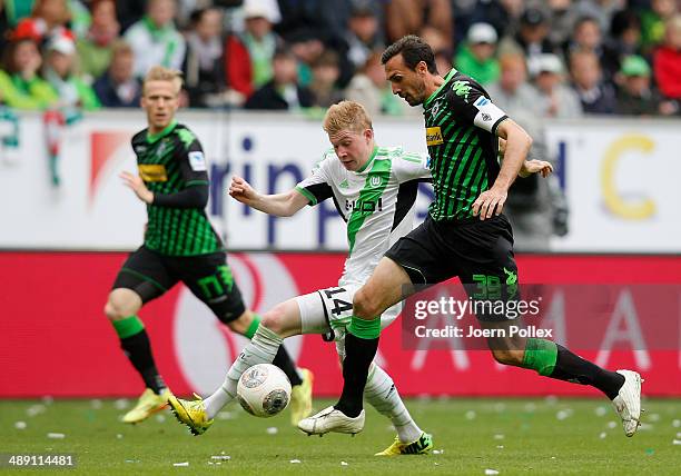 Kevin De Bruyne of Wolfsburg and Martin Stranzl of Moenchengladbach compete for the ball during the Bundesliga match between at Volkswagen Arena on...