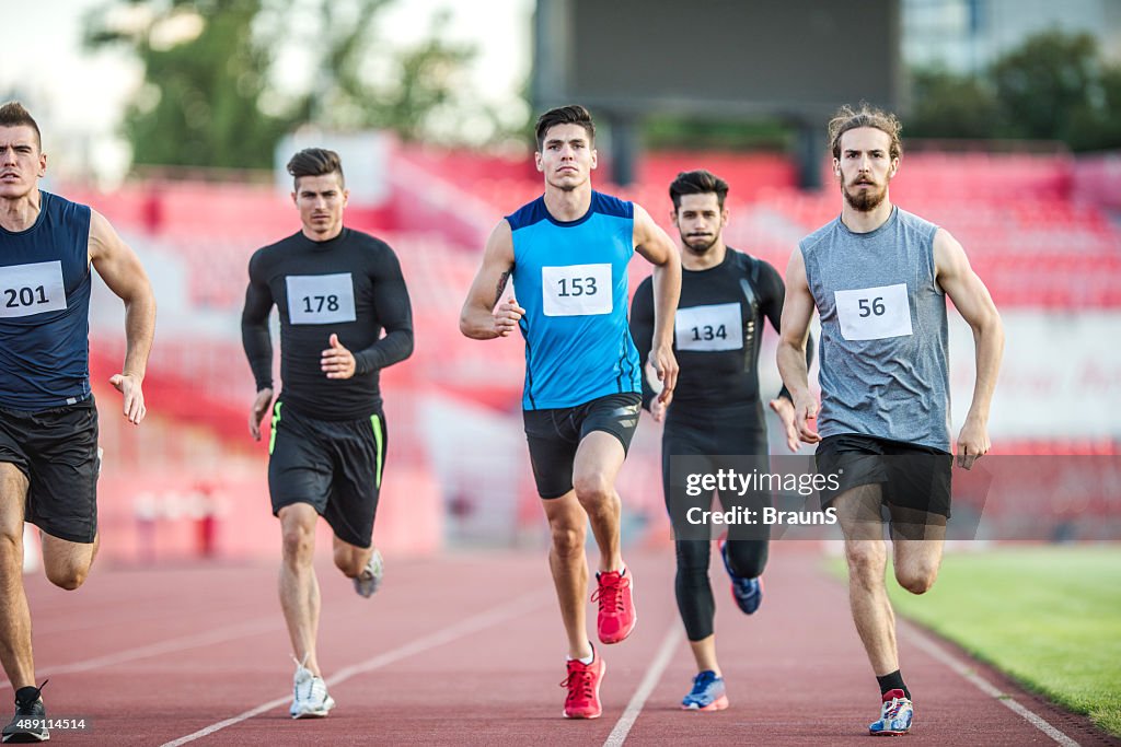Group of young athletic men having a sports race.