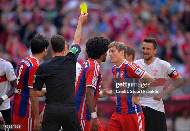 Toni Kroos aappeals to referee Bastian Dankert as he shows a yellow card during the Bundesliga match between Bayern Muenchen and VfB Stuttgart at...
