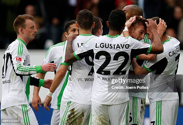 Robin Knoche of Wolfsburg celebrates with his team mates after scoring his team's third goal during the Bundesliga match between at Volkswagen Arena...