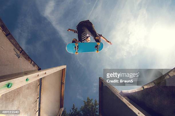 below view of a young skateboarder in ollie position. - stunt stock pictures, royalty-free photos & images
