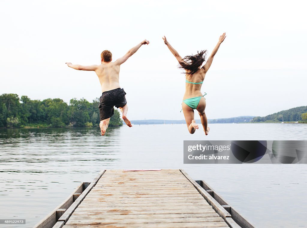 Good friends jumping into the lake