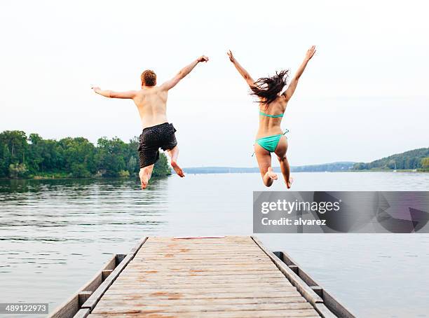 good friends jumping into the lake - jumping into lake stock pictures, royalty-free photos & images