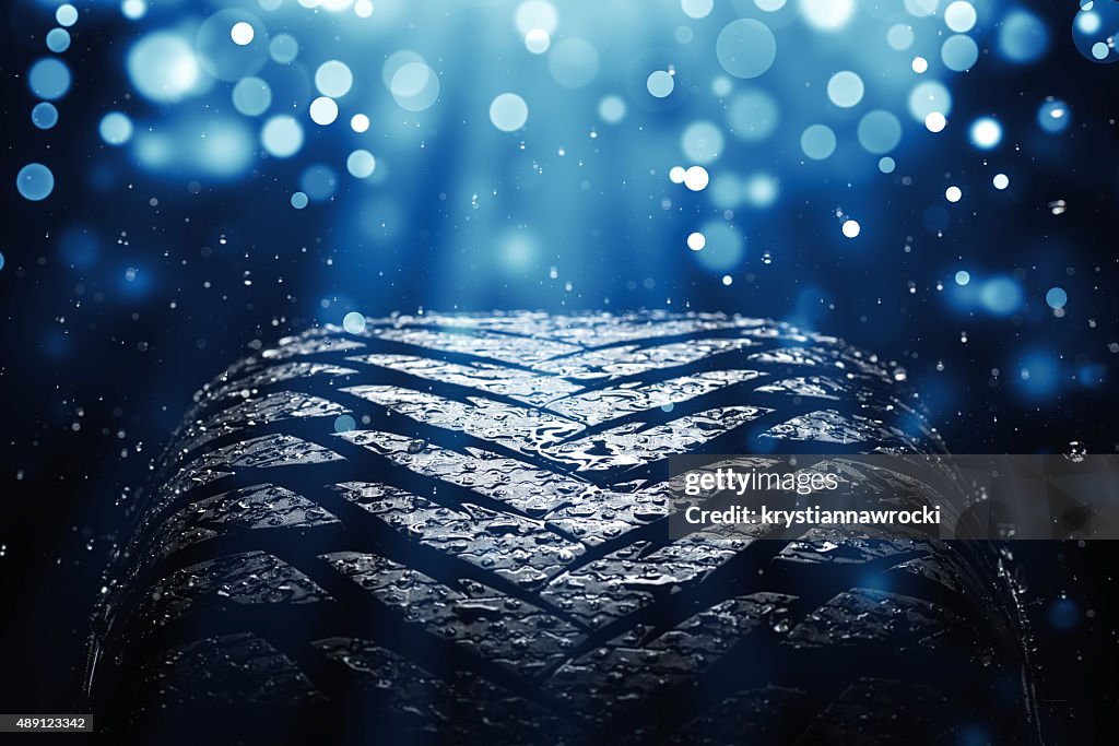 New wet tire while raining with blue light and sparkles