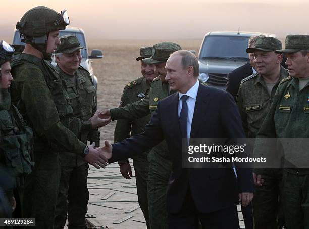 Russian President Vladimir Putin talks to officers as he attends Russias large-scale Center-2015 military exercises at Donguzsky Range September 19,...