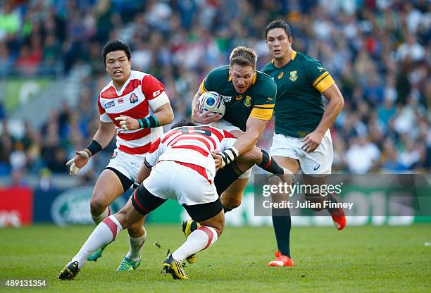 Jean De Villiers of South Africa is tackled by Ayumu Goromaru of Japan during the 2015 Rugby World Cup Pool B match between South Africa and Japan at...