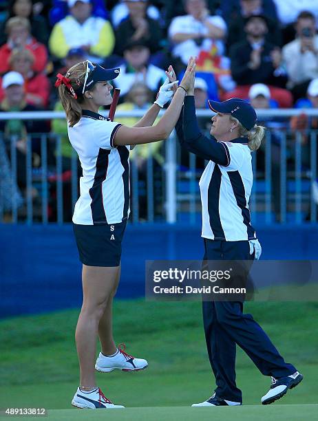 Cristie Kerr of the United States races to celebrate with Lexi Thompson after Thompson had holed a birdie putt on the 15th hole against Azahara Munoz...