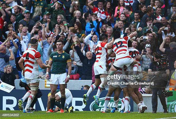 Karne Hesketh of Japan celebrates with his teammates following his winning try during the 2015 Rugby World Cup Pool B match between South Africa and...