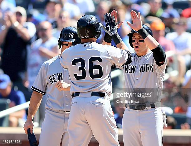 Jacoby Ellsbury and Brett Gardner of the New York Yankees celebrate with Carlos Beltran after Beltran drove them all in with a home run in the first...
