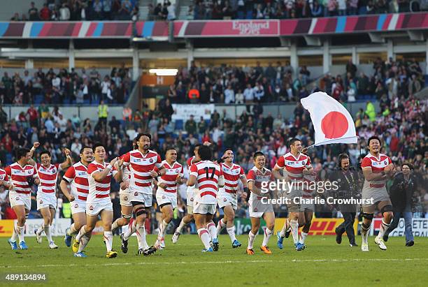Ecstatic Japan players celebrate their surprise victory in the 2015 Rugby World Cup Pool B match between South Africa and Japan at the Brighton...