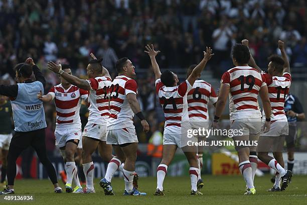 Japan's players celebrate winning the Pool B match of the 2015 Rugby World Cup between South Africa and Japan at the Brighton community stadium in...