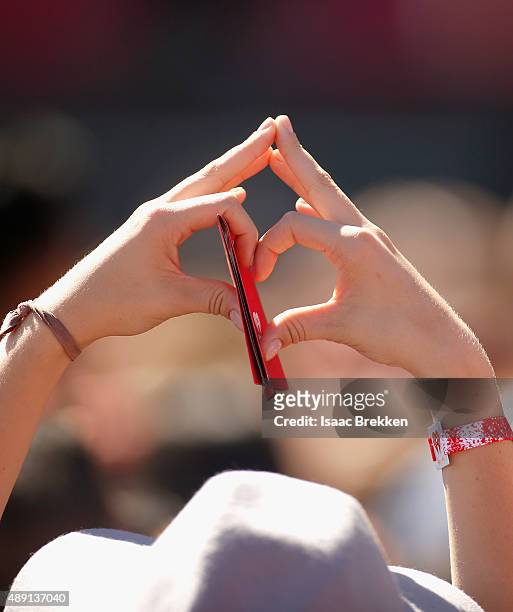 Fan in the crowd forms a heart with her hands at The Daytime Village during the 2015 iHeartRadio Music Festival at the Las Vegas Village on September...