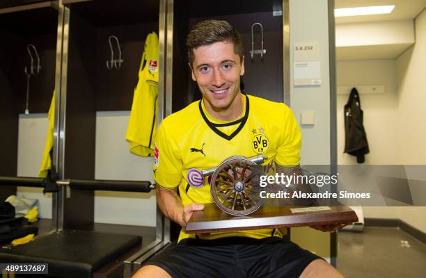 Robert Lewandowski of Borussia Dortmund celebrates receiving the trophy for being the league's topscorer of this season after the Bundesliga match...