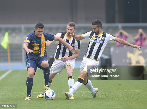 Marquinho of Hellas Verona compete with Thomas Heurtaux and Giampiero Pinzi of Udinese Calcio during the Serie A match between Hellas Verona FC and...