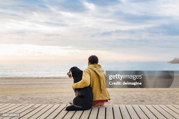 woman hugging her dog - promenade stockfoto's en -beelden