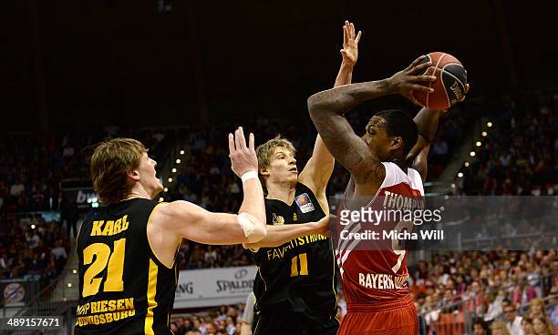 Coby Karl and Tim Koch of Ludwigsburg compete with Deon Thompson of Muenchen for the ball during game one of the 2014 Beko BBL Playoffs semifinals...