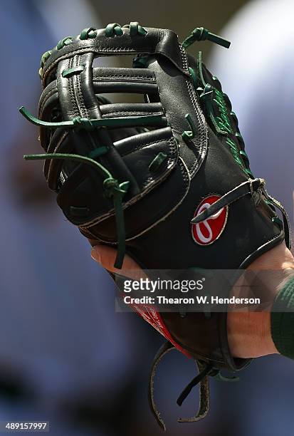 Detailed view of Daric Barton of the Oakland Athletics checking out his Rawlings first baseman's glove during game one of a doubleheader against the...
