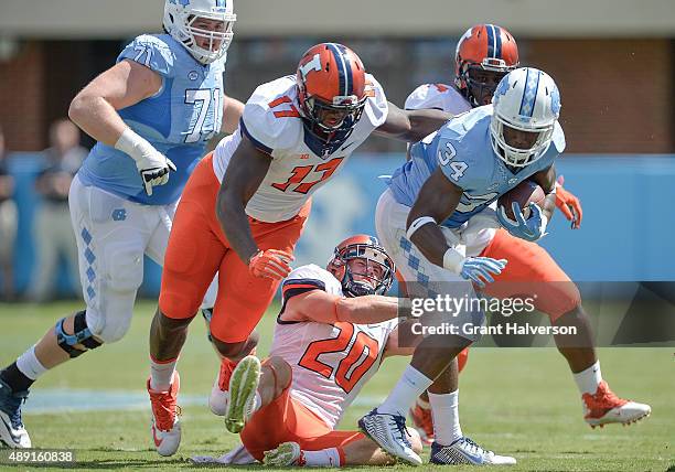 Jihad Ward and Clayton Fejedelem of the Illinois Fighting Illini tackle Elijah Hood of the North Carolina Tar Heels during their game at Kenan...