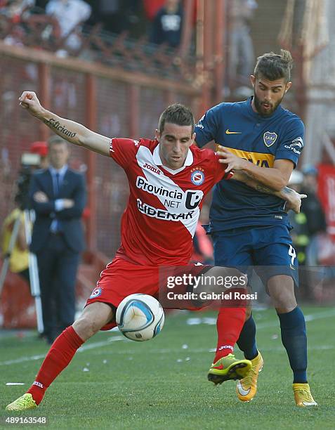 Andres Franzoia of Argentinos Juniors fights for the ball with Gino Peruzzi of Boca Juniors during a match between Argentinos Juniors and Boca...