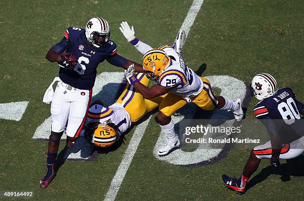 Jeremy Johnson of the Auburn Tigers runs past Donte Jackson and Rickey Jefferson of the LSU Tigers in the second quarter at Tiger Stadium on...