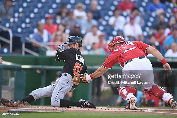 Ichiro Suzuki of the Miami Marlins beats the tag by Wilson Ramos of the Washington Nationals on a Christain Yelch single in the first inning during a...