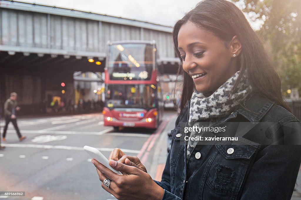 Woman using the new technologies for a taxi in London