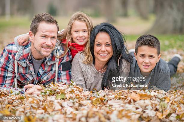 family lying in a pile of leaves - fat man lying down stock pictures, royalty-free photos & images