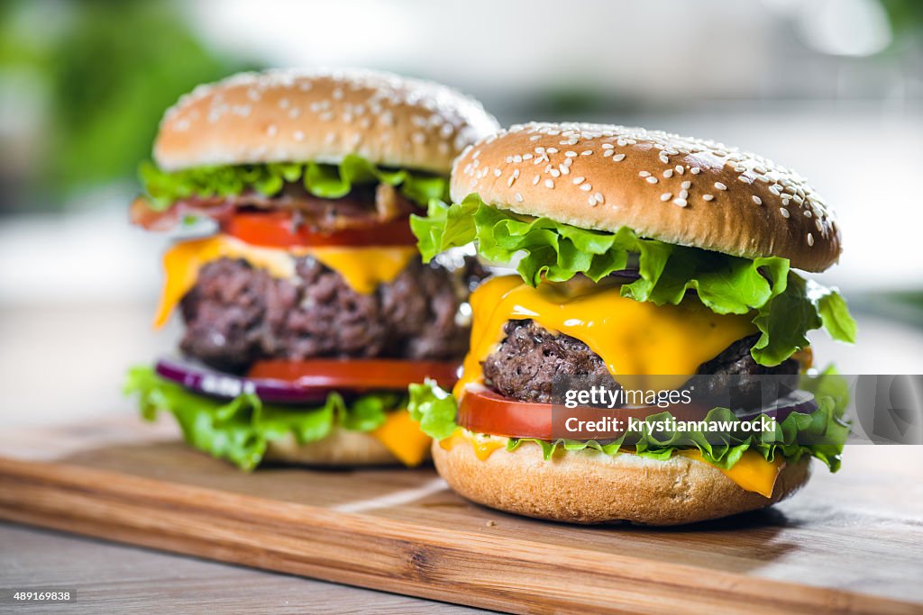 Two Home Made Huge Cheeseburger on oak chopping board