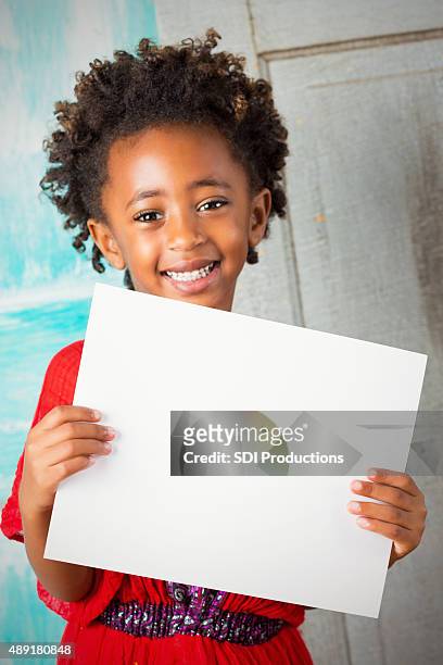 beautiful ethiopian child smiling while holding blank sign - blank sign stock pictures, royalty-free photos & images