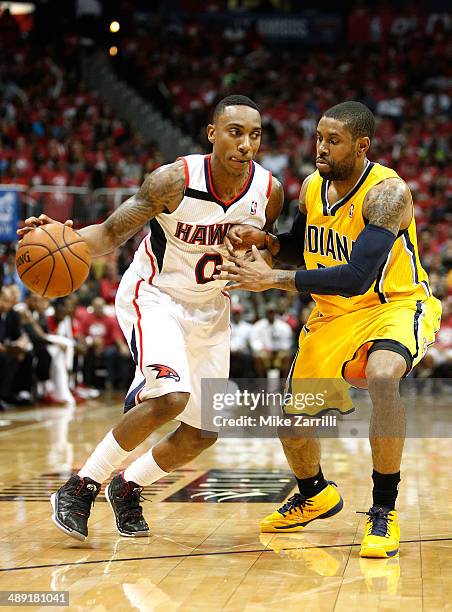 Guard Jeff Teague of the Atlanta Hawks dribbles while being defended by guard C.J. Watson of the Indiana Pacers in Game Six of the Eastern Conference...