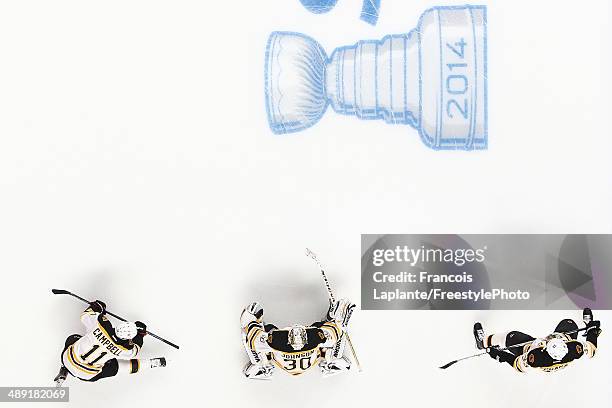 Gregory Campbell, Chad Johnson and Zdeno Chara of the Boston Bruins warms-up over the in ice Stanley Cup logo during warmup prior to Game Three of...