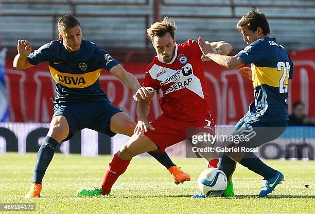 Lautaro Rinaldi of Argentinos Juniors fights for the ball with Fernando Tobio and Andres Cubas of Boca Juniors during a match between Argentinos...