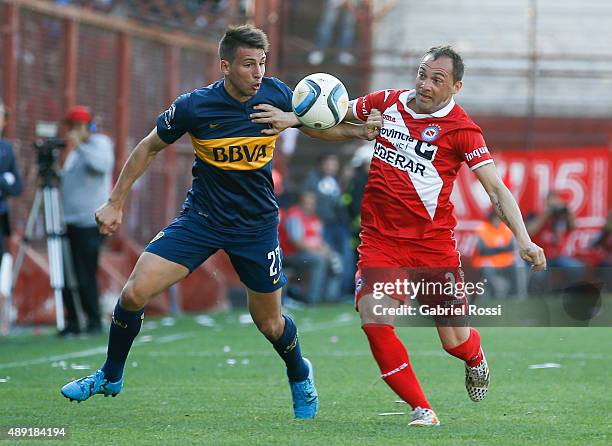 Jonathan Calleri of Boca Juniors fights for the ball with Ezequiel Garre of Argentinos Juniors during a match between Argentinos Juniors and Boca...