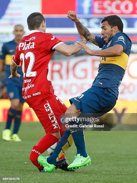 Ezequiel Ham of Argentinos Juniors is fouled and injured by Carlos Tevez of Boca Juniors during a match between Argentinos Juniors and Boca Juniors...