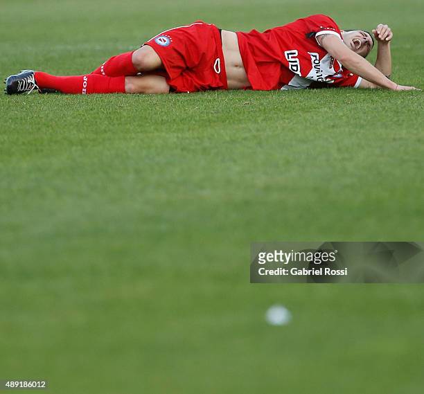 Ezequiel Ham of Argentinos Juniors lies injuried after receiving a foul from Carlos Tevez of Boca Juniors during a match between Argentinos Juniors...