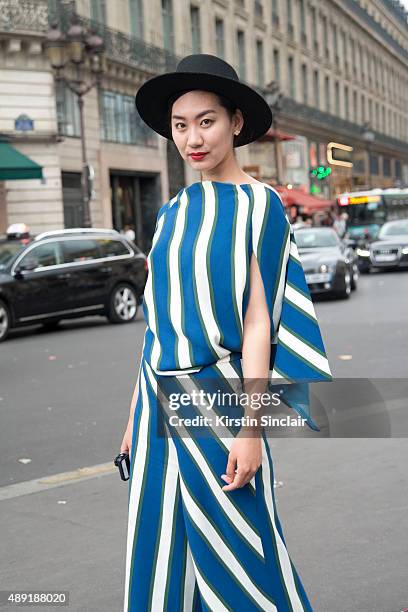 Huang Waiu Qing wears a Woodbox jumpsuit, Zara Sandals and a Woodbox hat on day 4 of Paris Fashion Week Haute Couture Autumn/Winter 2015 on July 8,...
